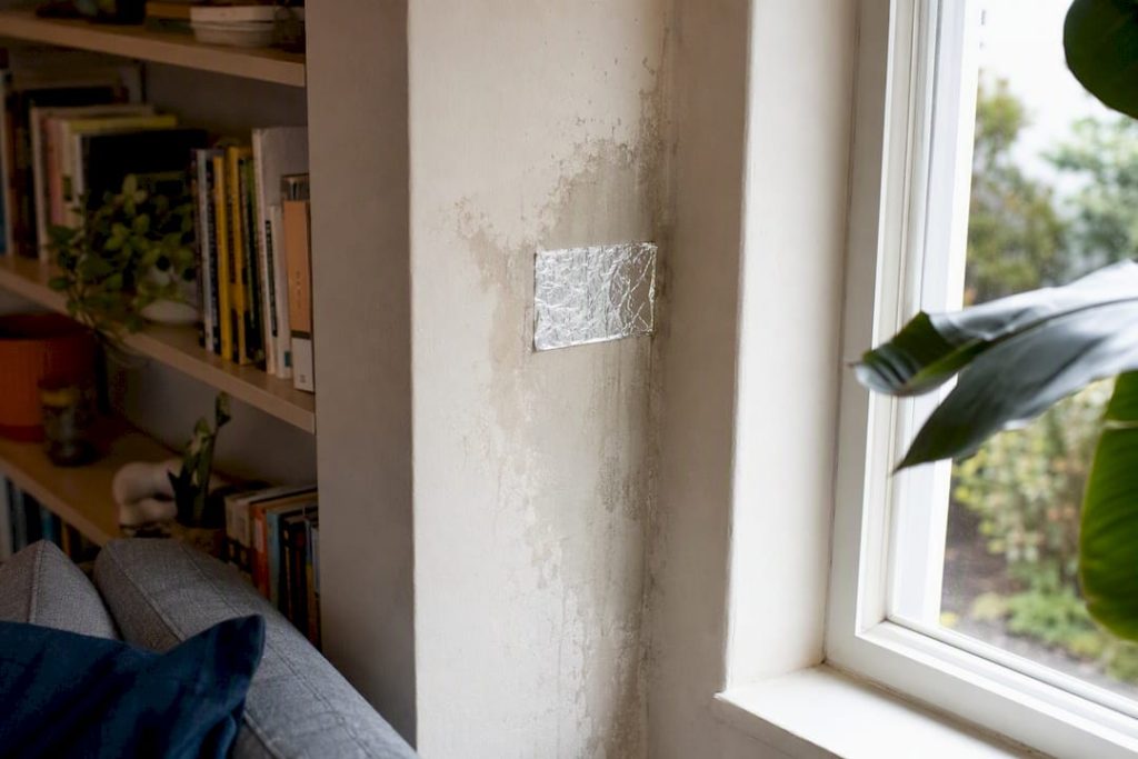 Foil taped to damp wall showing condensation